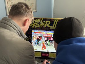 Zwei Schüler spielen Street Fighter an einer Konsole